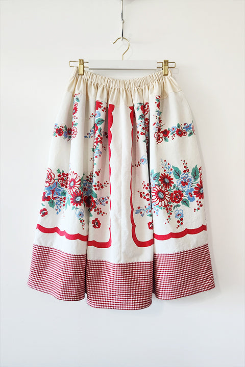 cottagecore style josephine midi skirt made from a red and blue floral tablecloth and a red gingham curtain