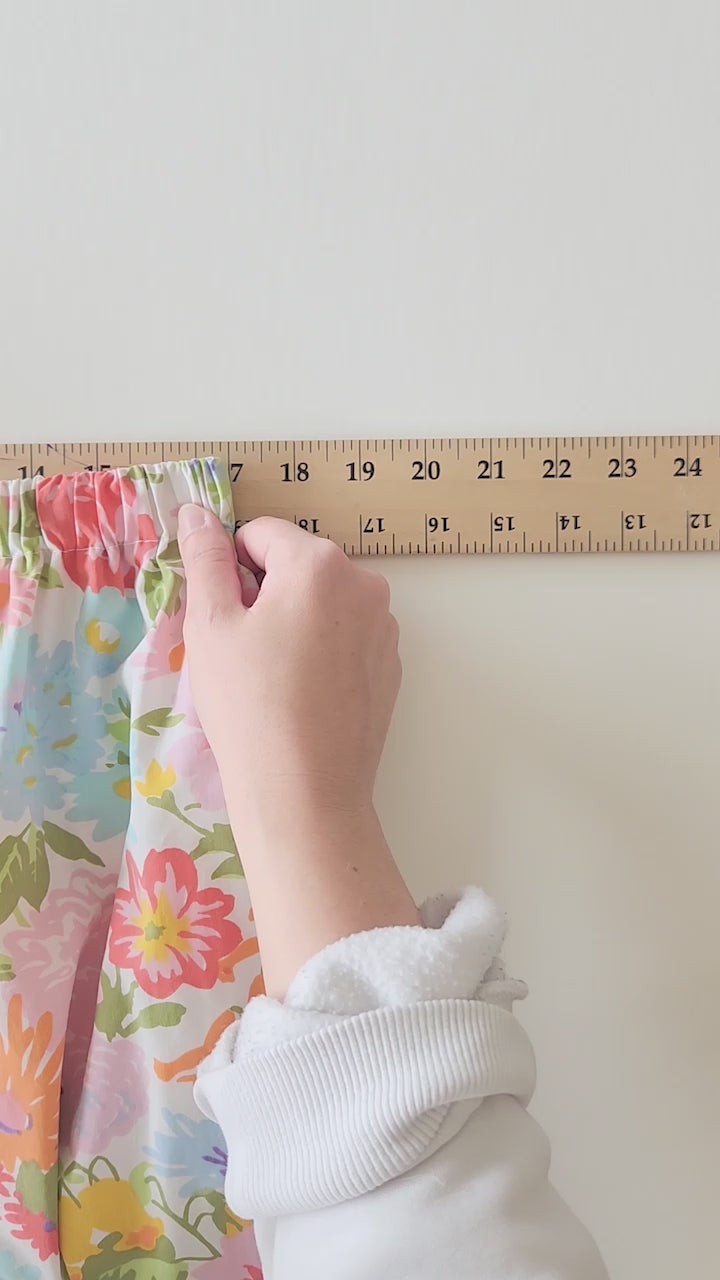 a video of an elastic waist skirt being stretched on a wooden yard stick.  The skirt starts off at 17" and then is repeatedly stretch by hand  to over 24" on the ruler.