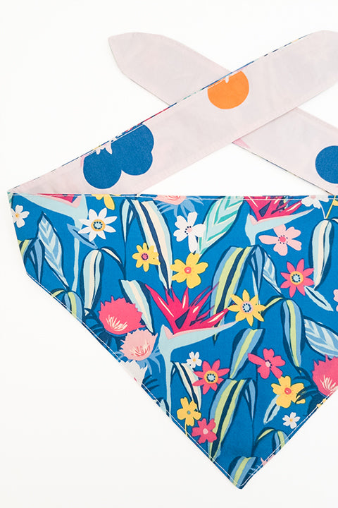 tropical floral print detail view of berry tropical reversible pet bandana. print features blues, pinks, yellows, oranges and greens.