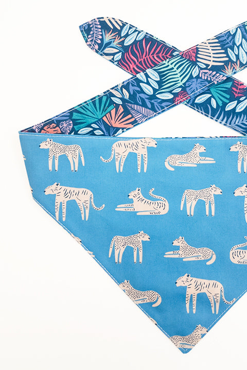 tiger print side detailed view of jungle friends reversible pet bandana. prints feature jungle animals, plants and tigers on blue backgrounds.
