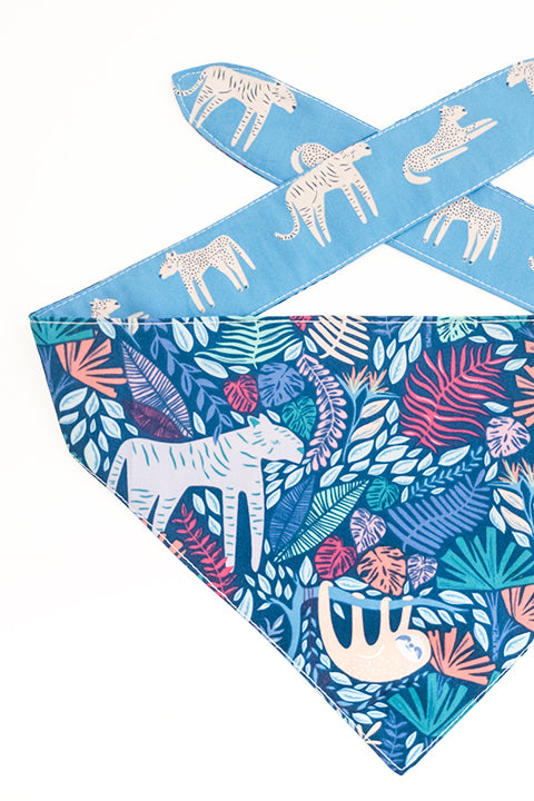 jungle animals print side detailed view of jungle friends reversible pet bandana. prints feature jungle animals, plants and tigers on blue backgrounds.