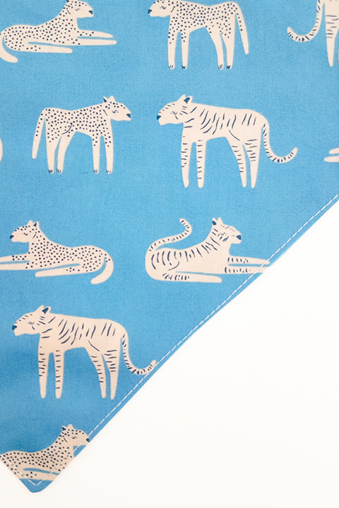 tiger print side zoomed in detail of jungle friends reversible pet bandana. prints feature jungle animals, plants and tigers on blue backgrounds.