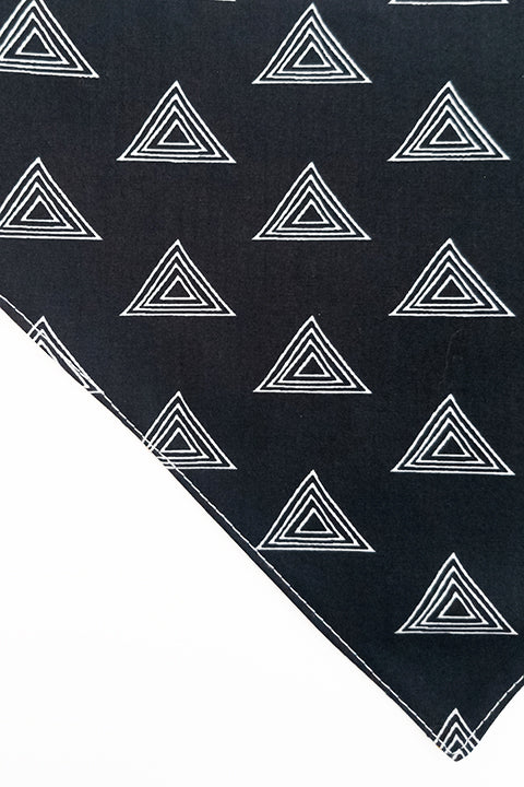 black and white pyramids print side zoomed in detail of pyramids and grid reversible pet bandana. prints feature black, white, yellow and blue.