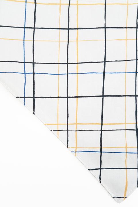 thin plaid print side zoomed in detail of pyramids and grid reversible pet bandana. prints feature black, white, yellow and blue.