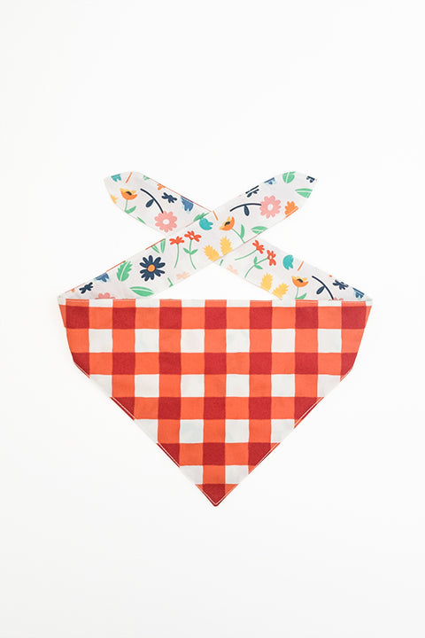 picnic plaid print side of spring picnic reversible pet bandana. prints feature a colorful floral and red and cream buffalo plaid.