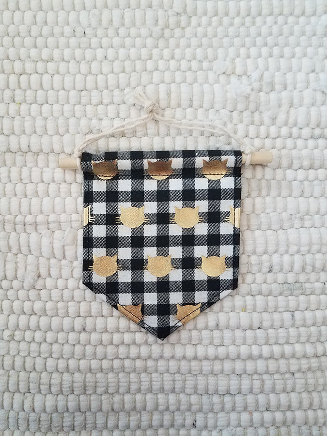 mini handmade pennant ornament featuring a black and white buffalo check fabric printed with gold cat faces