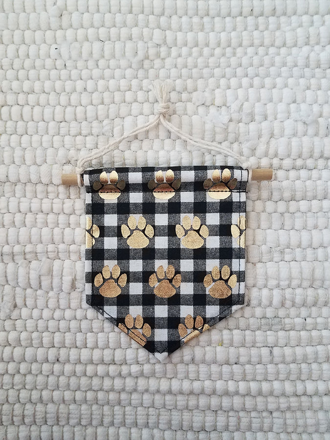 mini handmade pennant ornament featuring a black and white buffalo check printed with gold paws