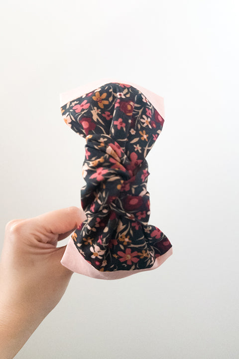 top knot view of an upcycled handmade headband created with two different scrap fabrics, a blush pink and a mini floral print