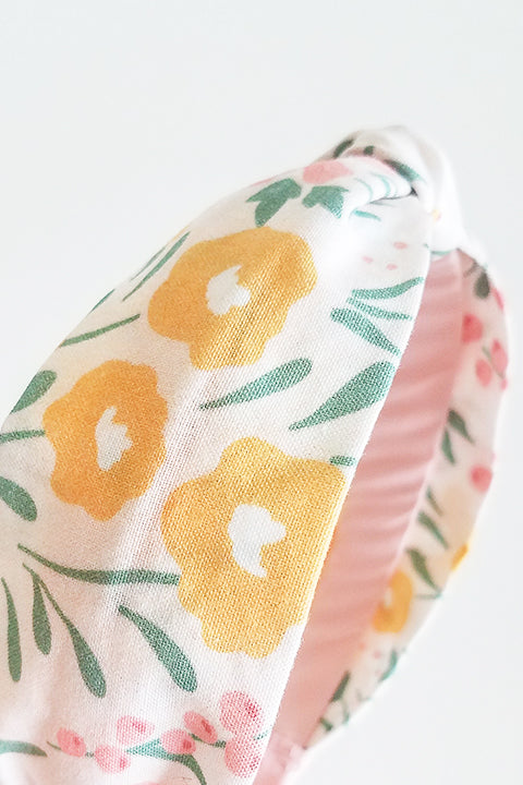 detail side view upcycled handmade headband made from a 100% cotton fabric scraps in a happy floral print with cream, mustard yellow, green and pink