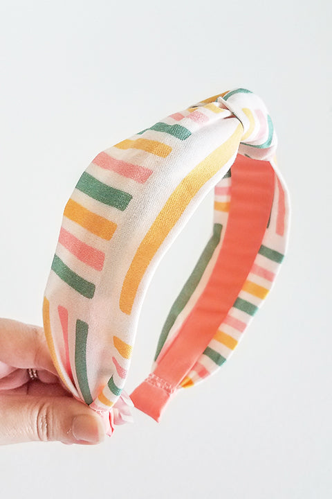 side view upcycled handmade headband made from a 100% cotton fabric scraps in a happy stripes geometric print with cream, mustard yellow, green and pink