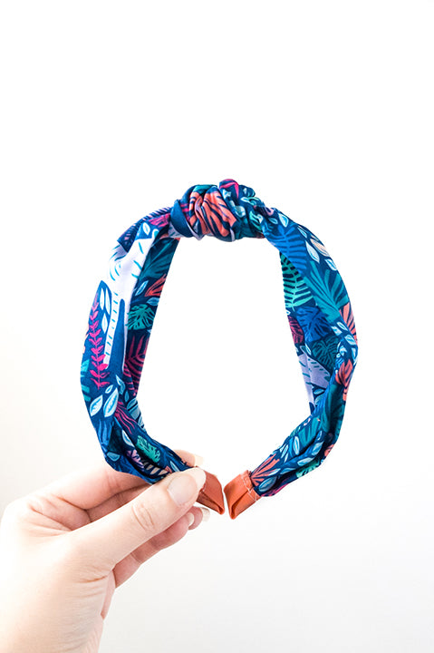front view of an upcycled cotton fabric headband featuring a top knot and tropical jungle friends animal print fabric