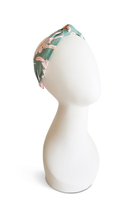 upcycled handmade headband made from a 100% cotton fabric scraps in a verdant floral print with green, cream, pink and mustard. shown on a white model head form.