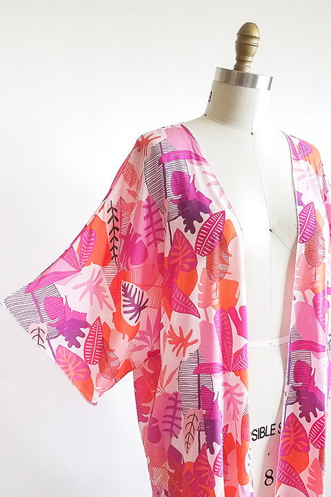 sleeve view of small batch open front fashion kimono made from a 100% rayon hot pink tropical leaf print fabric shown on a dress form