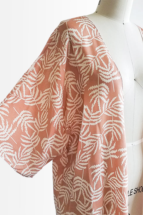 sleeve view of small batch open front fashion kimono made from a 100% rayon cinnamon pink fabric printed with white fern leaves shown on a dress form