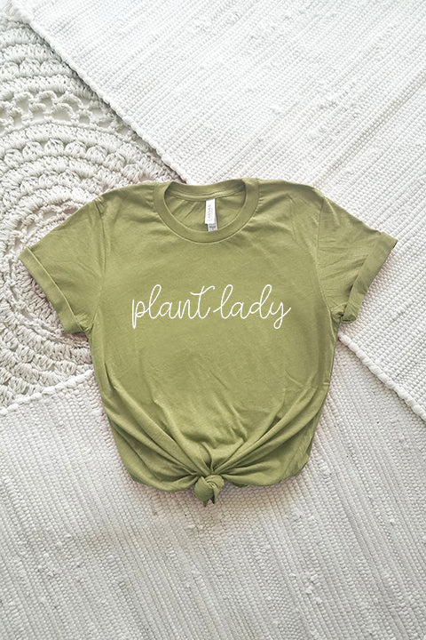 flat image of bella and canvas cotton blend tee in heather olive with a design in white script that says plant lady