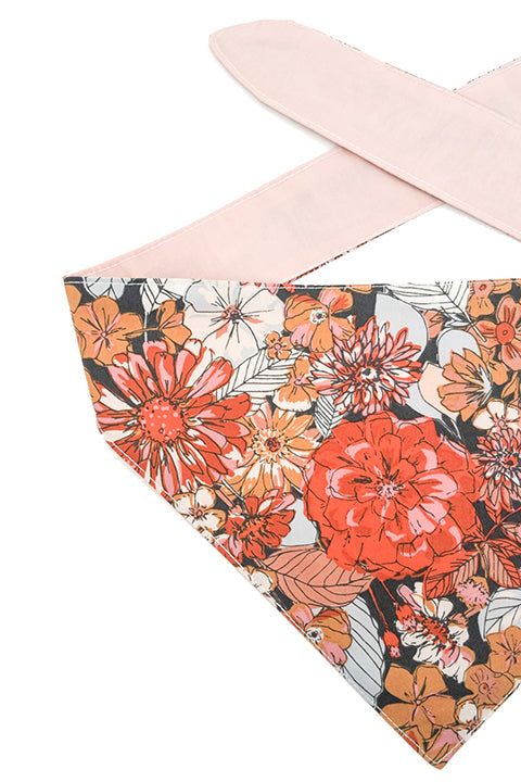 detailed view of a 100% premium cotton reversible 2 in 1 pet bandana made in a rustic blooms floral print for the front and a blush pink solid fabric for the reverse