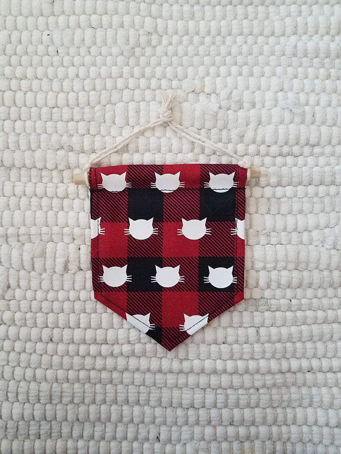mini handmade pennant ornament featuring black and red buffalo plaid printed with white cat faces
